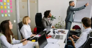 Thank you for the clarification. Here's the corrected **alt text** using the exact keyword: **Alt Text:** Team participating in leadership development programs during an interactive office training session.